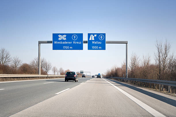 Road sign on german autobahn A66 Road sign on german autobahn A66 - some minor motion blurring. Road sign directs to the highway junction Wiesbadener Kreuz- next exit Wallau autobahn stock pictures, royalty-free photos & images