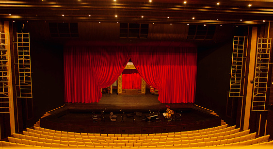 View from the balcony on seats and stage in the large theater and orchestra