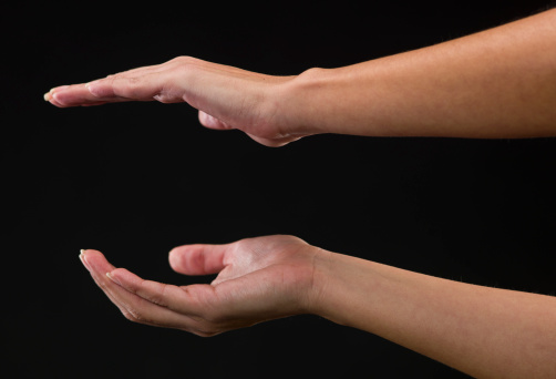 Two Woman hands holding an imaginary object on black background