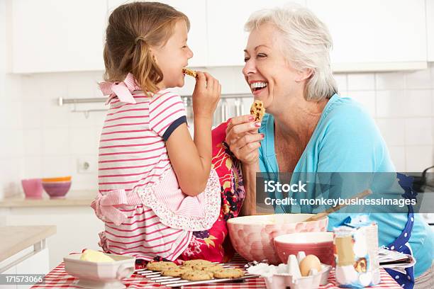 Grandma And Granddaughter Laugh And Bake Cookies Stock Photo - Download Image Now - Grandmother, Cookie, Grandchild