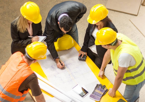 Construction team going over building blueprints stock photo