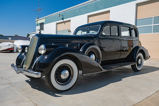 A vintage black 1936 Pierce Arrow sedan with suicide doors, cleaned up and ready to be sold for auction.