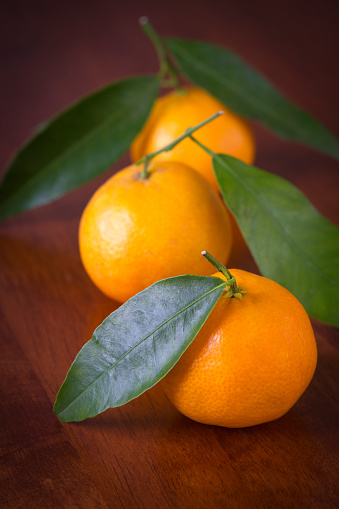 Two ripe juicy tangerines on a black background with drops of water.