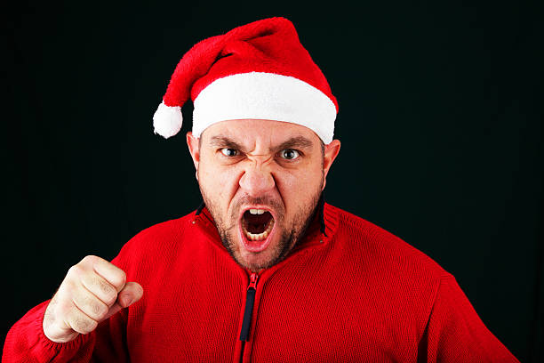 Punchy Santa A man wearing a Santa hat puts his fist in the air and prepares to throw a punch.  I wonder what made him so angry? punching one person shaking fist fist stock pictures, royalty-free photos & images