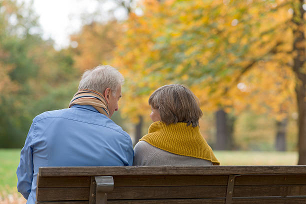 istock Senior couple sitting on park bench in autumn 171574169