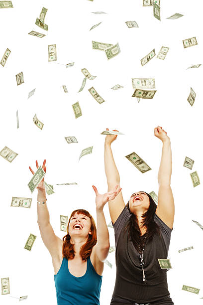 istock Two laughing young women try to catch many falling dollars 171574513