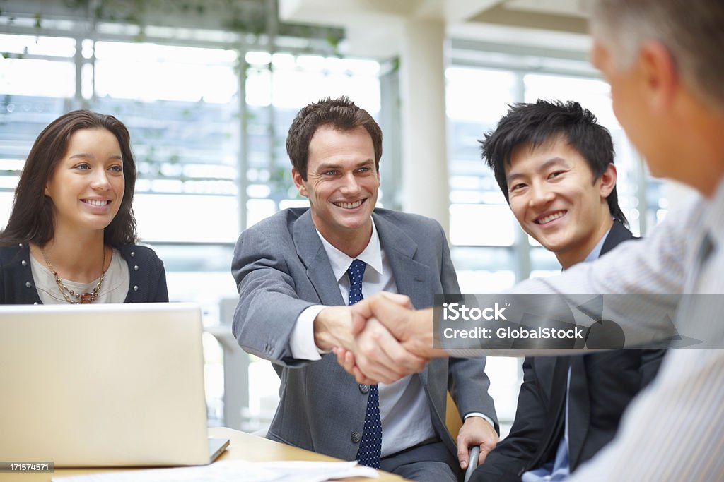 Hombres de negocios estrechándose las manos - Foto de stock de 40-49 años libre de derechos