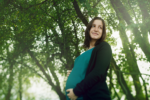 Happy pregnant woman portrait in nature
