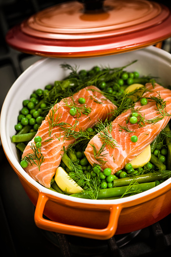Salmon fillet with green beans, peas, and dill in a casserole