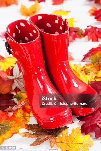 Foto de Botas De Borracha Vermelha Em Folhas De Outono e mais fotos de stock de Galocha - Galocha, Plástico, Acessório