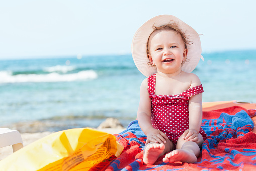 Cute 18-month old toddler having fun on beach