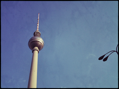 The famous landmark near Alexanderplatz in Berlin, Germany: Fernsehturm (Television Tower). There is a street lamp to the right giving perspective.This image was taken with a mobile phone.See also: