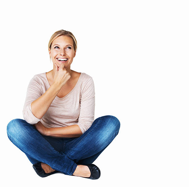 What to do today? A beautiful young woman sitting down and looking happy while isolated on white cross legged stock pictures, royalty-free photos & images