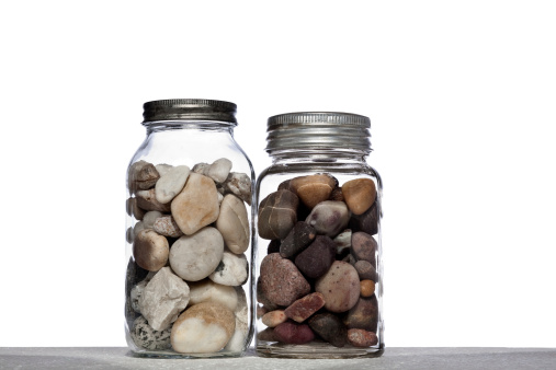 Two mason jars filled with rocks on a white background.