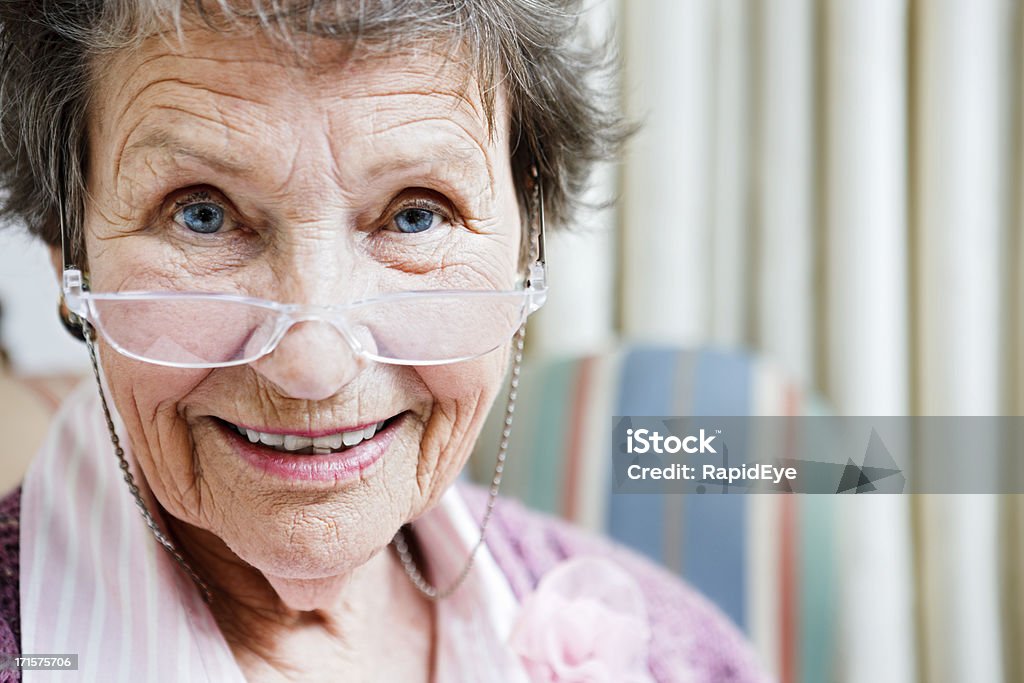 Ligeramente disbelieving vista de un sonriente mujer senior - Foto de stock de 80-89 años libre de derechos