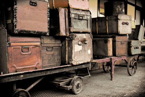 Vintage luggage and trolleys on a railway platform.