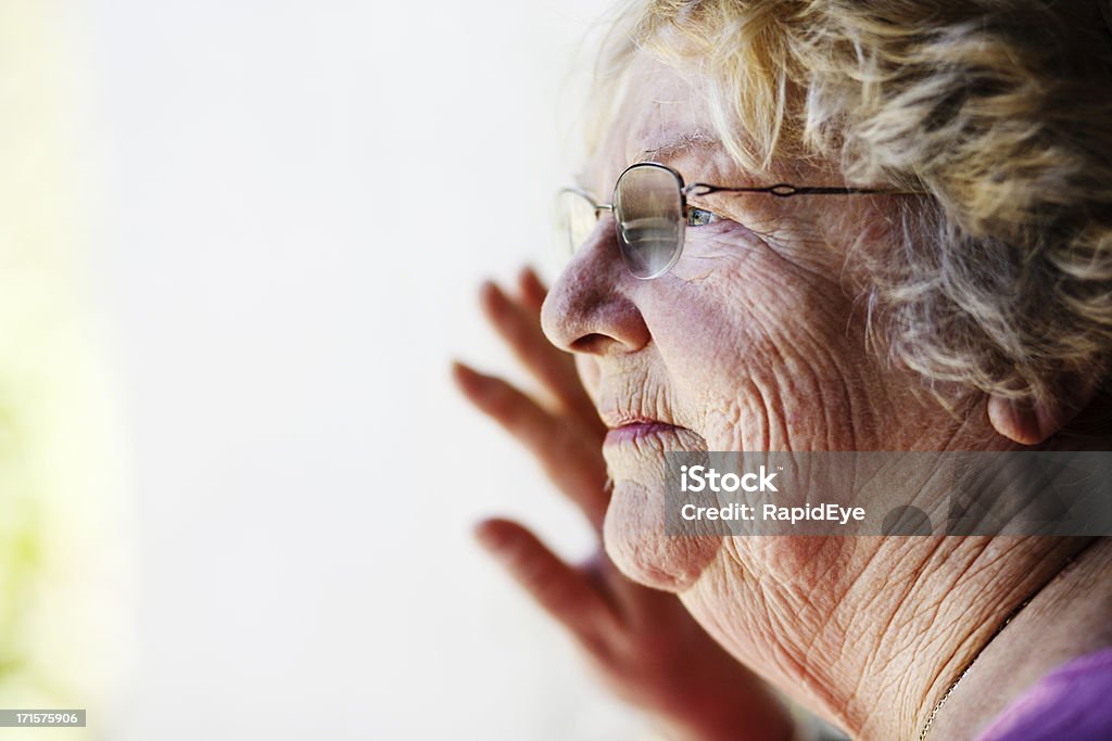 Graves old lady espera a través de la ventana - Foto de stock de Contemplación libre de derechos