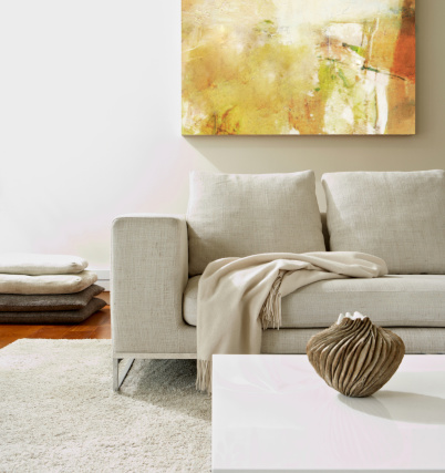 Empty modern living room with white rug and a modern vase on coffee table.  Square composition. 