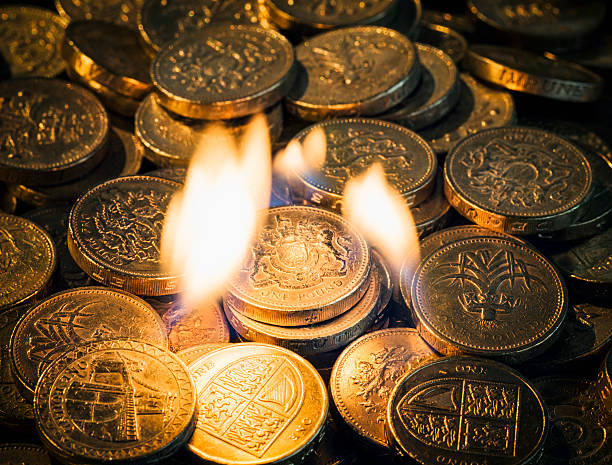 burning dinero - one pound coin coin uk british currency fotografías e imágenes de stock