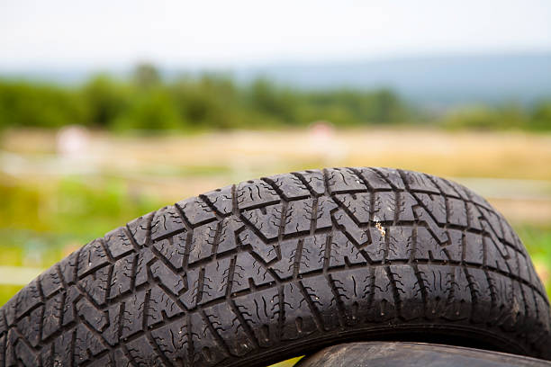 small rocks stuck in car tire tread, closeup.