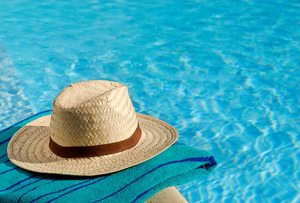 istock A sun hat sitting on a towel at the edge of a pool 171576080