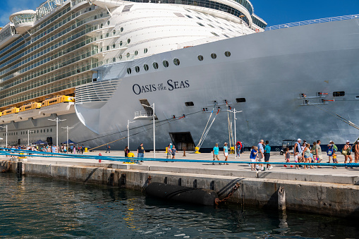 Nassau, Bahamas - September 21, 2023: Disembarking passengers walk toward town, passing the Royal Caribbean International cruise ship Oasis of the Seas.