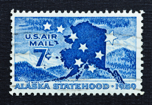 The Post Office Department issued a 7-cent Alaska Statehood commemorative airmail stamp at the Juneau, Alaska, post office on January 3, 1959, the date of Alaska's admission to the Union...The stamp features the Big Dipper and North Star (as portrayed on the Alaskan flag) superimposed on a map of Alaska. In the background appear wooded hills and snow-topped mountains, indicative of the terrain and the vastness of the area and its wealth.