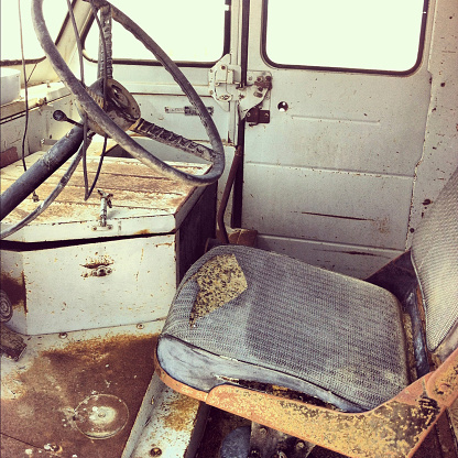 Interior of an old abandoned delivery truck that is weathered and falling apart.  Photo captured with an iPhone.