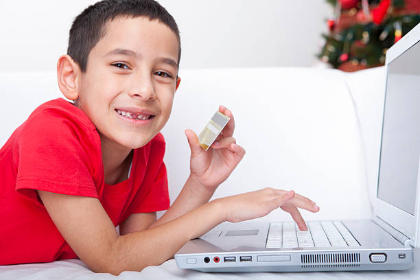 クリスマスのオンラインショッピングハッピーな少年 - paying children only retail childhood ストックフォトと画像