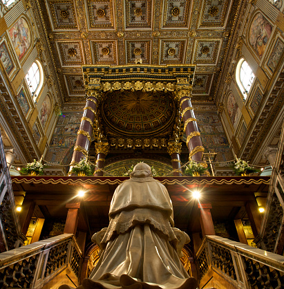 Basilica Of Santa Maria Maggiore in Rome, Italy. S\ttatue of Pope Pio IX in reverent pose fronting the altar that holds the urn of Valadier, which contains five wooden boards, blackened by age, believed to form the crib of the Holy Infant Jesus Christ.