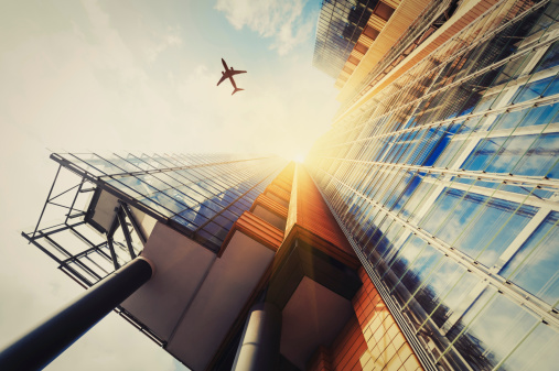 Skyscraper with a airplane silhouette in the sun