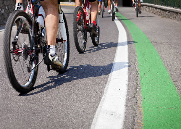 istock White And Green Line On Asphalt With Cyclists Passing By 171576872