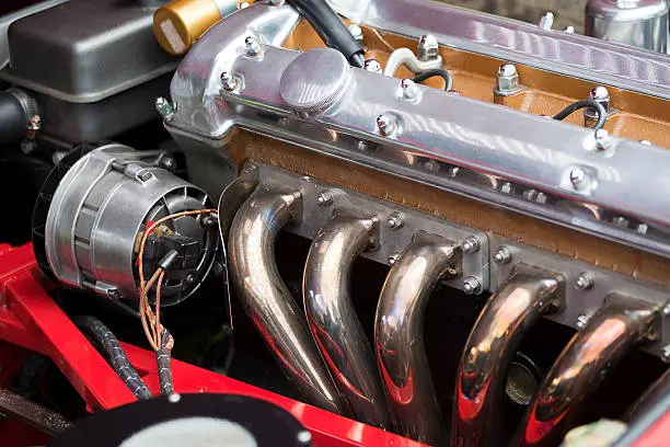 The engine of a classic Jaguar E-Type car;  six cylinders, triple SU carbs.More Classic Car Details: