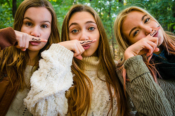 Those three cute teenage girls want to remember their dads, uncles and masculine members of their entourage that it is that time of year again to check for their specific health! Movember typical mustaches drawn to their fingersaA|