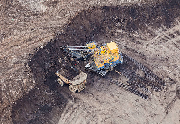 Mining Excavator A large power shovel excavates heavy oil loaded sand from a Alberta Oilsands open pit mine near Fort McMurray. oilsands stock pictures, royalty-free photos & images
