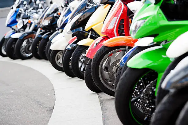 Photo of Row of motor scooters standing on the street, copy space