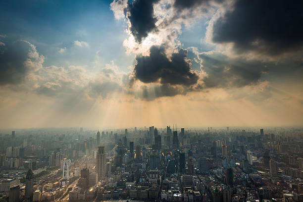Rays of sunlight bursting through a dramatic cloudscape above the crowded skyscrapers and city blocks of Shanghai, from The Bund down the Nanjing Road and the Huangpu district in the heart of China's fastest growing city. ProPhoto RGB profile for maximum color fidelity and gamut.