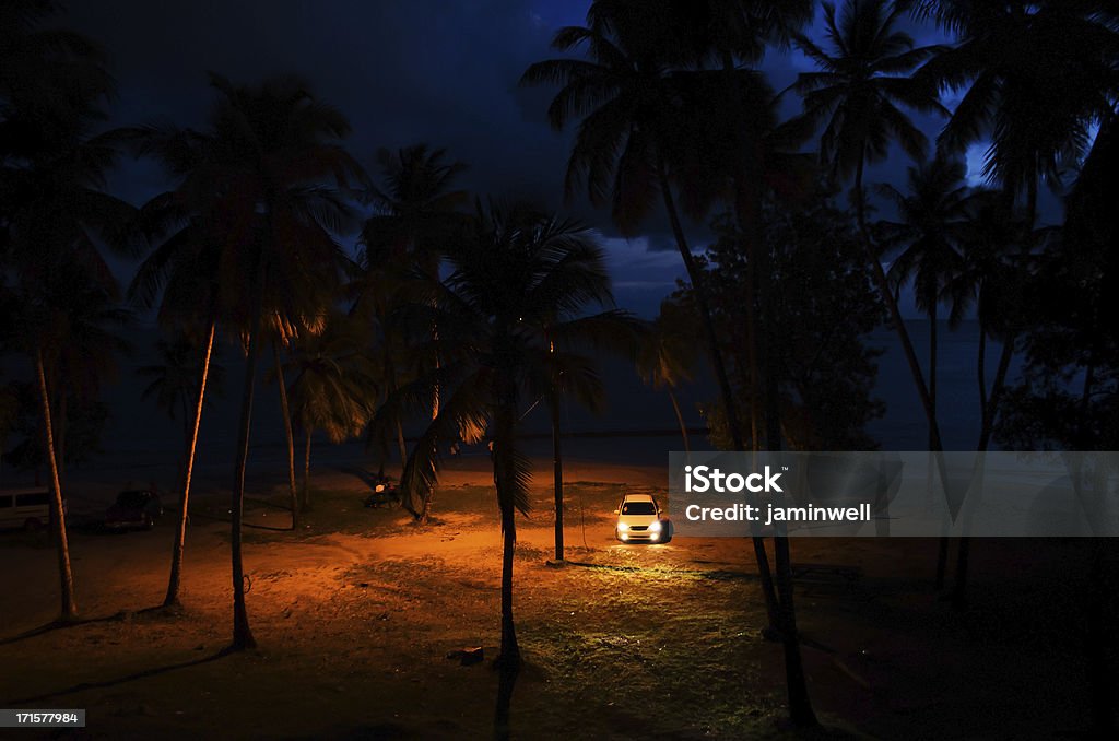Samochód w świetle reflektorów na plaży w nocy - Zbiór zdjęć royalty-free (Plaża)