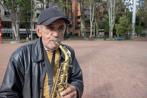 Senior playing sax in the street