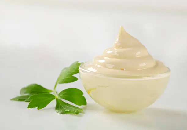 Mayonnaise in a glass bowl isolated on white