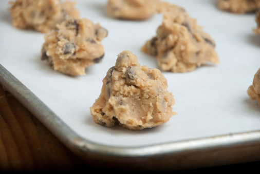 A pan of freshly prepared homemade chocolate chip cookie dough sits on the counter waiting to go into the oven.