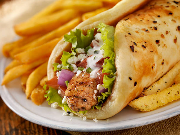 Chicken Souvlaki Wrap Chicken Souvlaki Pita Wrap with Lettuce, Tomatoes, Red Onions, Feta Cheese, Tzatziki Sauce and a Side of French Fries -Photographed on Hasselblad H3D-39mb Camera shawarma stock pictures, royalty-free photos & images