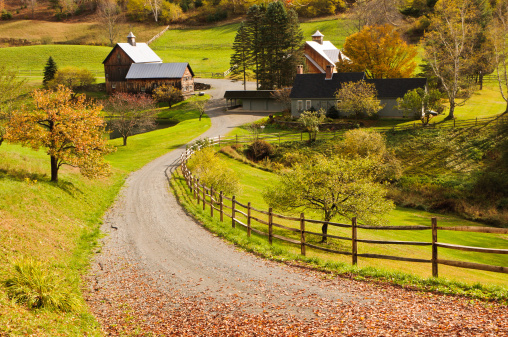 A leaf covered lane leads to a barn and house in a quiet hillside valley near Woodstock, Vermont