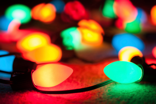 A string of old fashioned Christmas lights with selective focus on the foreground elements.