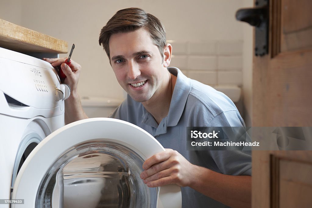 Engineer Mending Domestic Washing Machine Reliable service from local tradesman Repairing Stock Photo