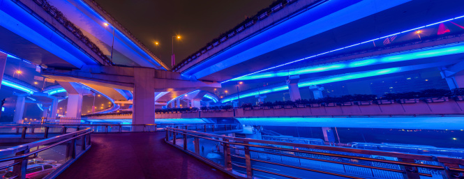Electric blue neon lights illuminating the futuristic walkways and mulit-layered highways of the Yan'an Expressway interchange in the Huangpu district of Shanghai, China. ProPhoto RGB profile for maximum color fidelity and gamut.