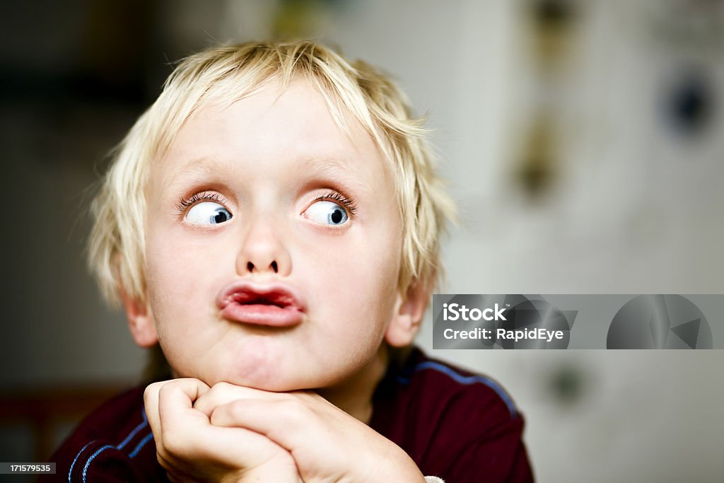 Seven-year-old boy rolls his eyes to the right Wide eyed, a boy grimaces as he looks to the right of frame, right where you can add your message. Shot with Canon EOS 1Ds Mark III. Child Stock Photo