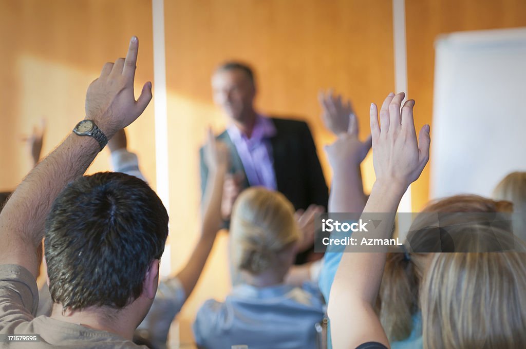 Parte posteriore del pubblico alzando le mani nel corso del seminario - Foto stock royalty-free di Riunione