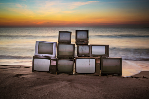 Old televisions in an early morning on the beach.