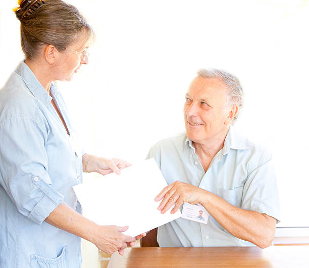 istock nurse handing documents to doctor 171579668